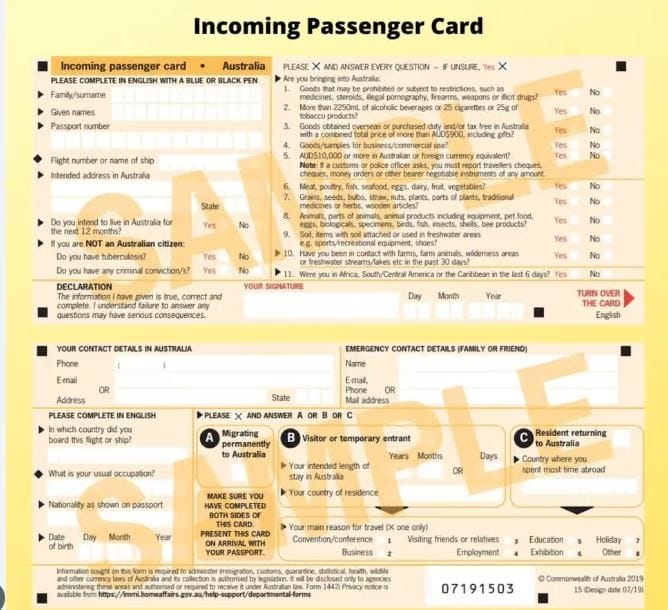 A hand holding a pen filling out an Australian Incoming Passenger Card, with a specific focus on declaring items for customs.